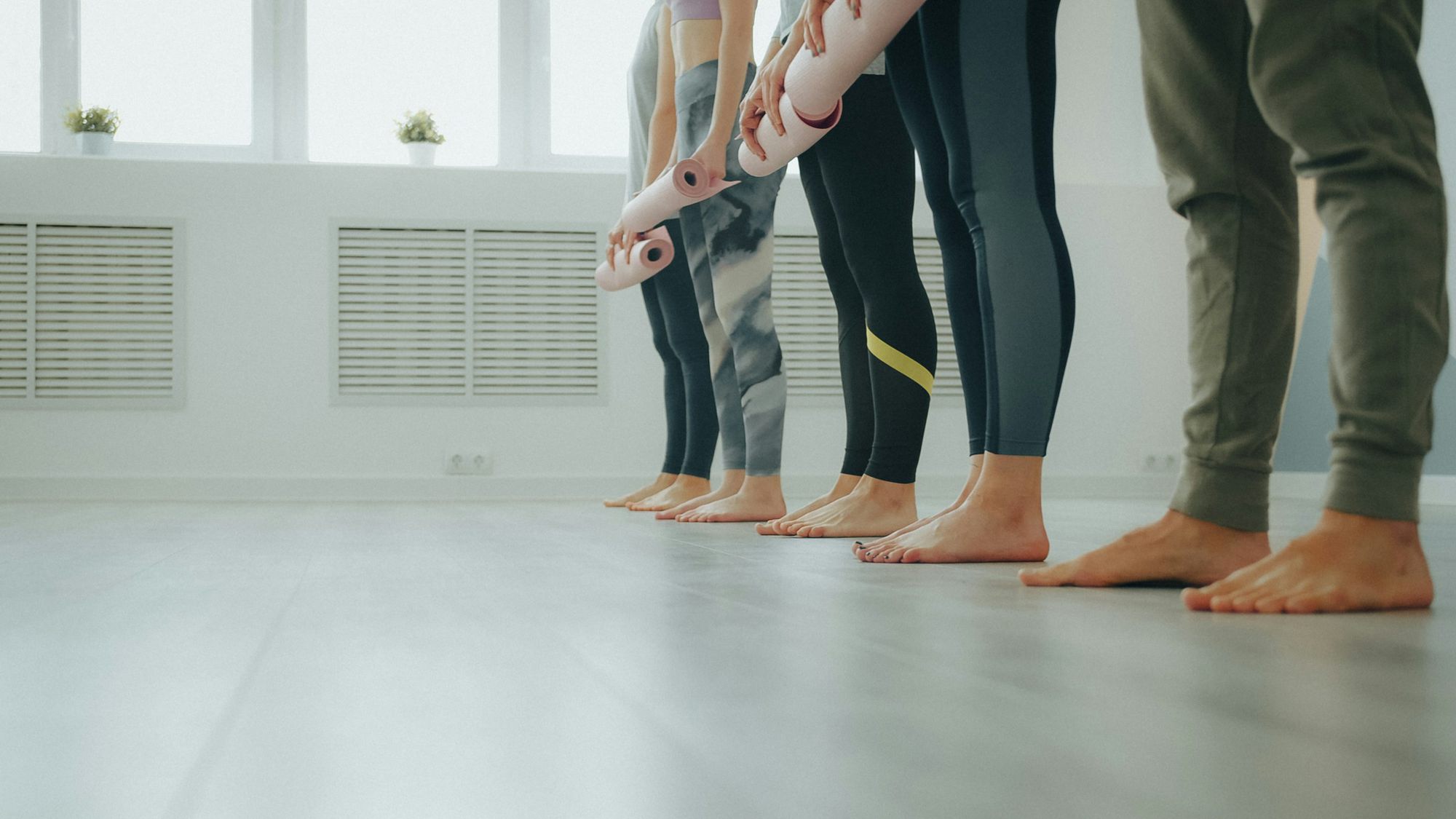 Bare feet in a row on a wooden floor at the back of the room