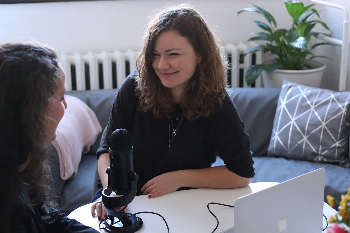 A reporter recording an interview with a microphone on a living-room table
