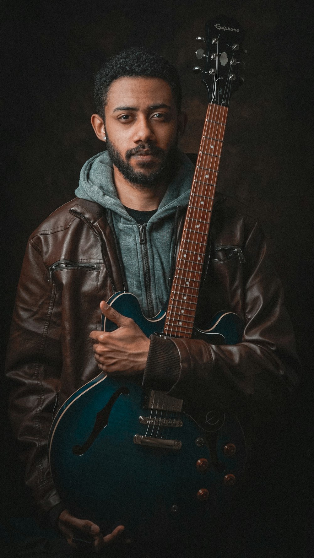 Portrait of Eli Brandt holding an electric guitar