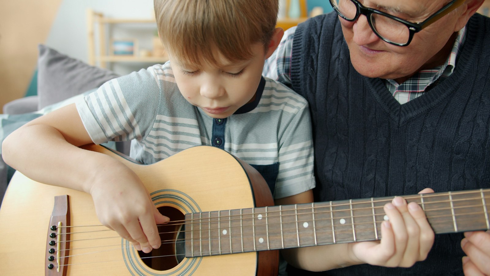 Walter Hale showing a young student a chord on the guitar