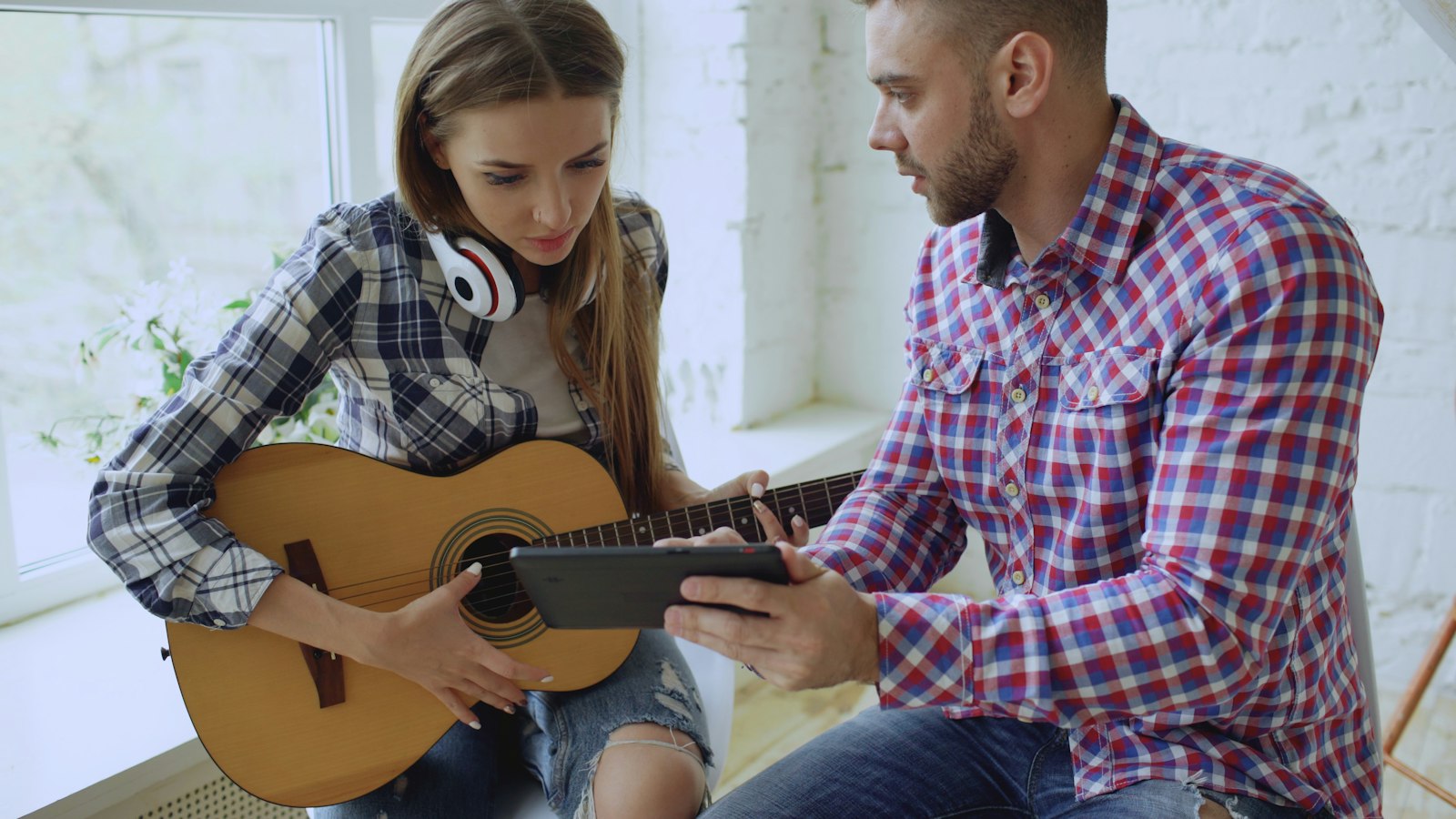 A teacher and student working through a song on guitar