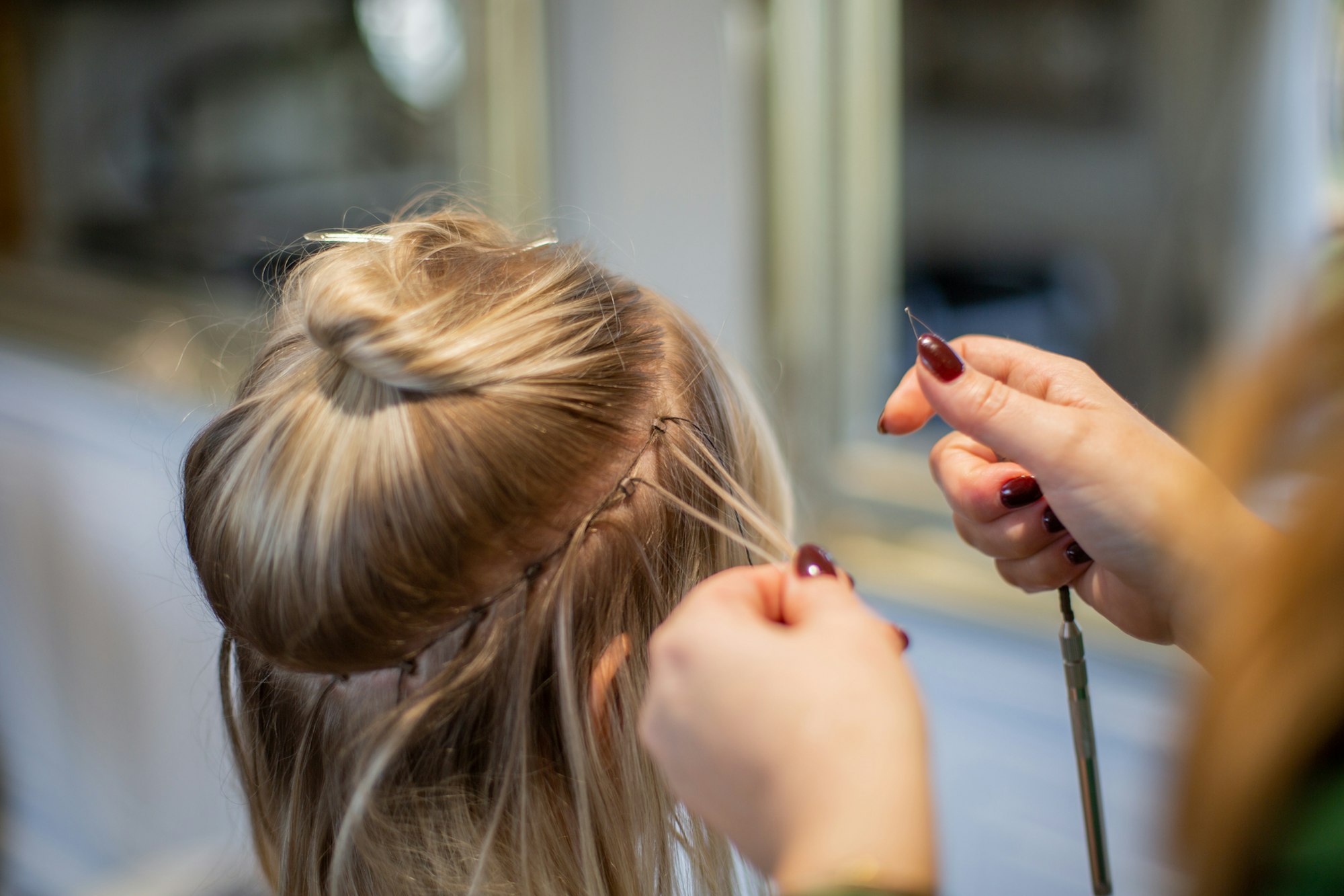 June pinning a hair vine into a bride's low bun