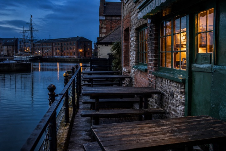 The wharfside terrace with benches looking over the water at dusk