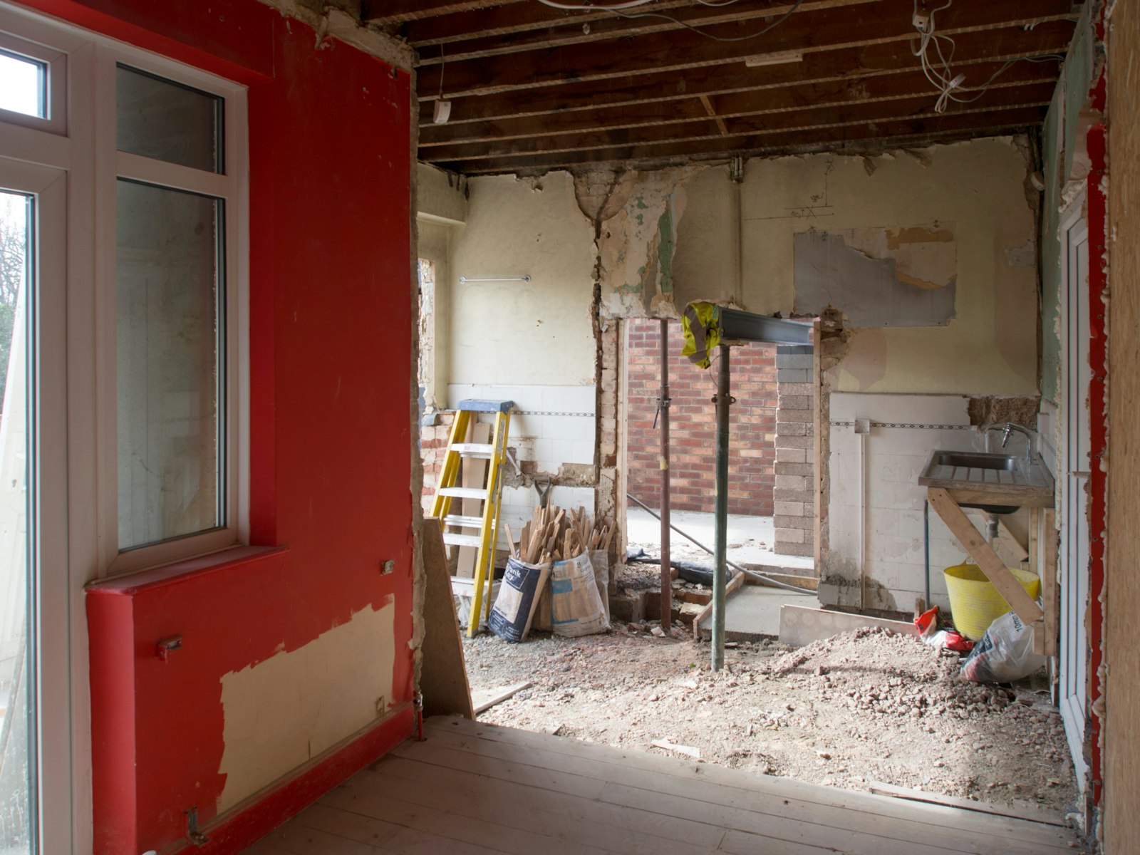 During: the same room opened to the joists, a new steel beam in and the floor dug out