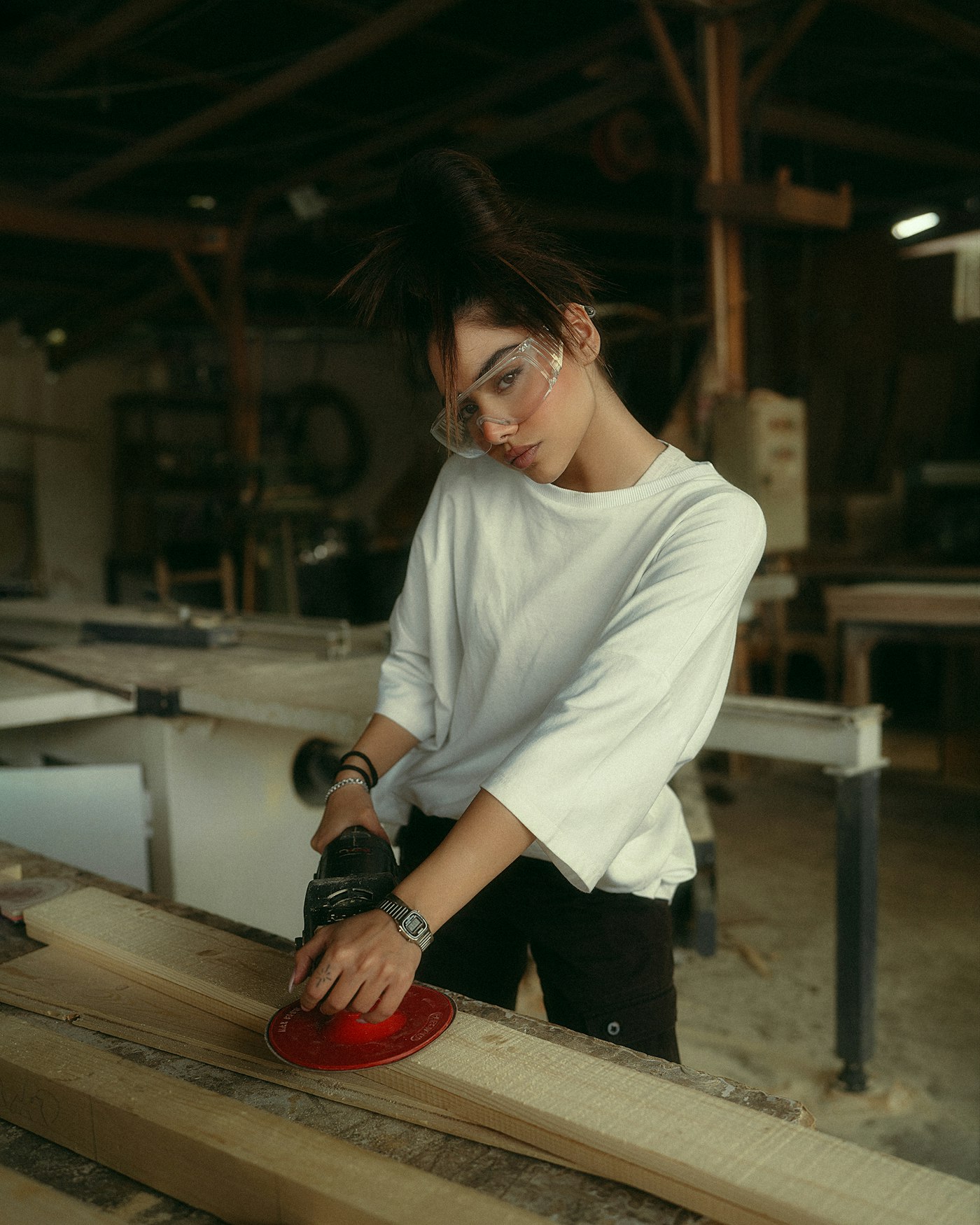Ana sanding a cabinet door in the shop