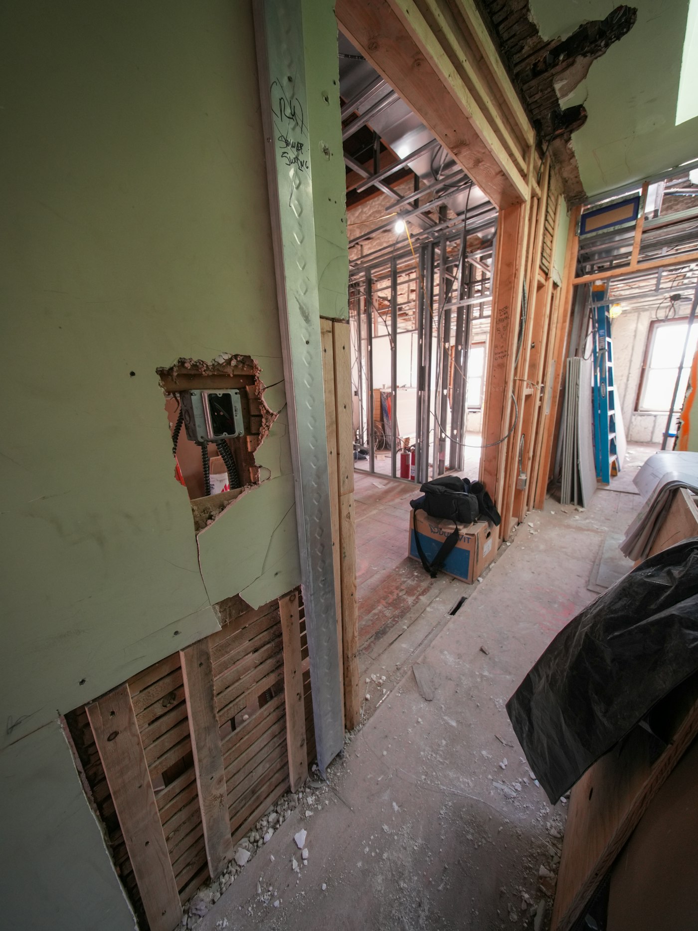 Mid-build: the bathroom wall opened to new framing and wiring