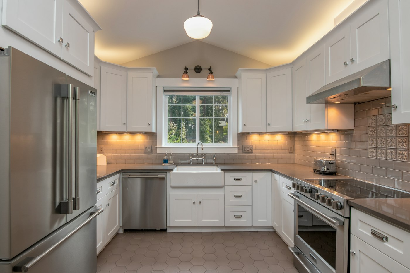 After: white cabinets to the ceiling and the sink under the window at the far end