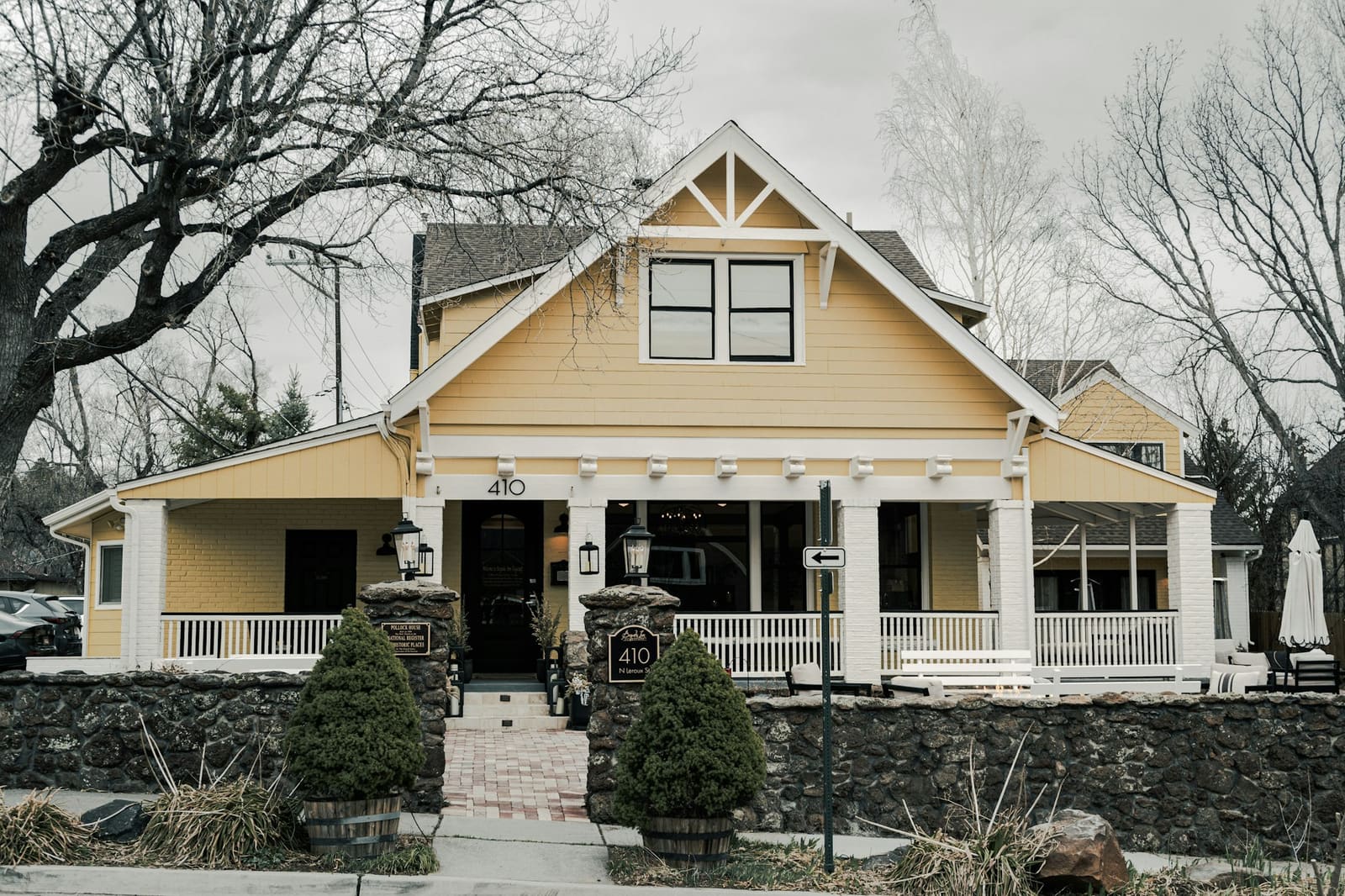 A yellow craftsman house with a stone porch