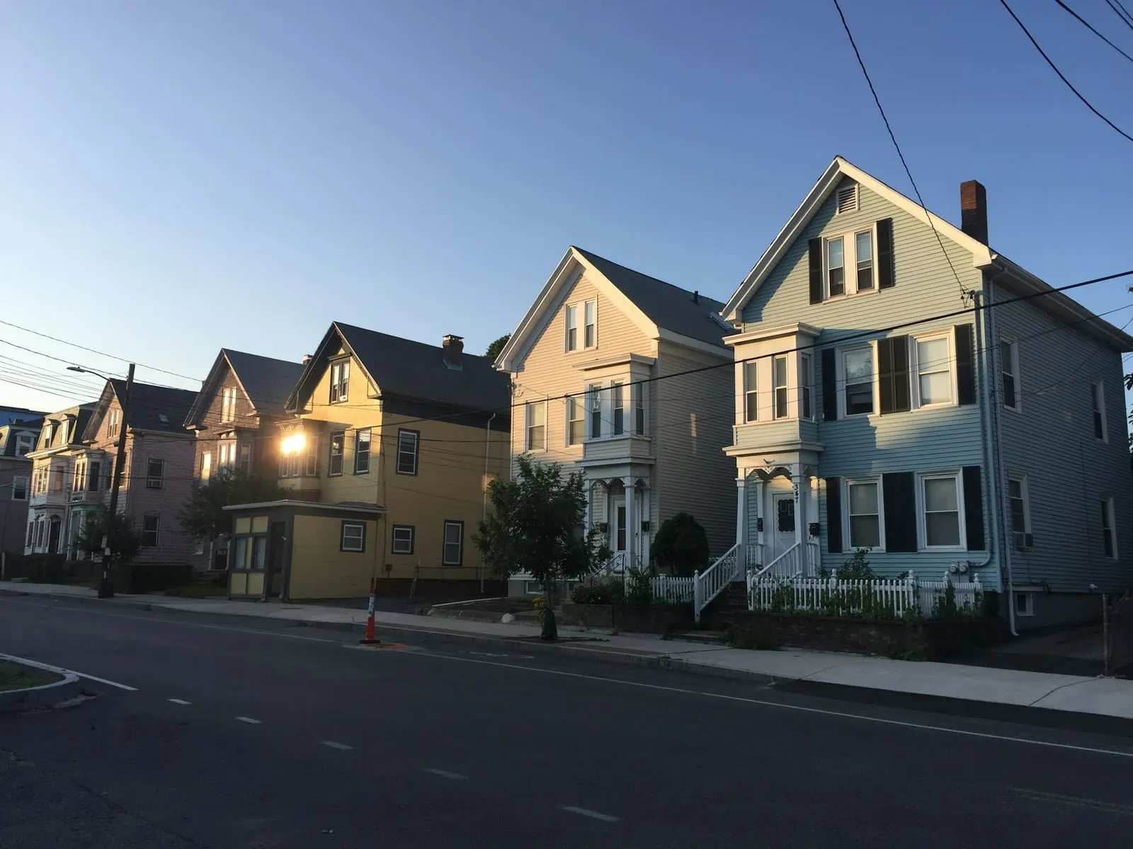A row of painted triple-decker houses with stacked porches