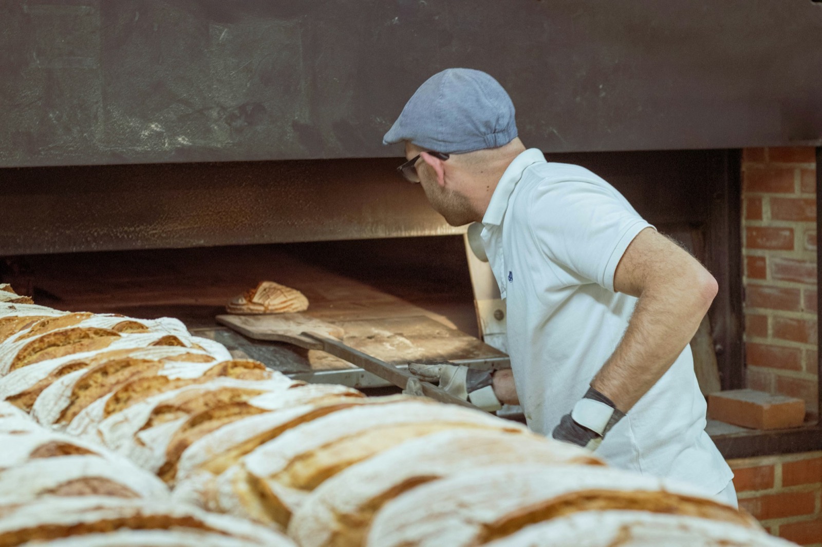 Anders at the deck oven with a row of loaves