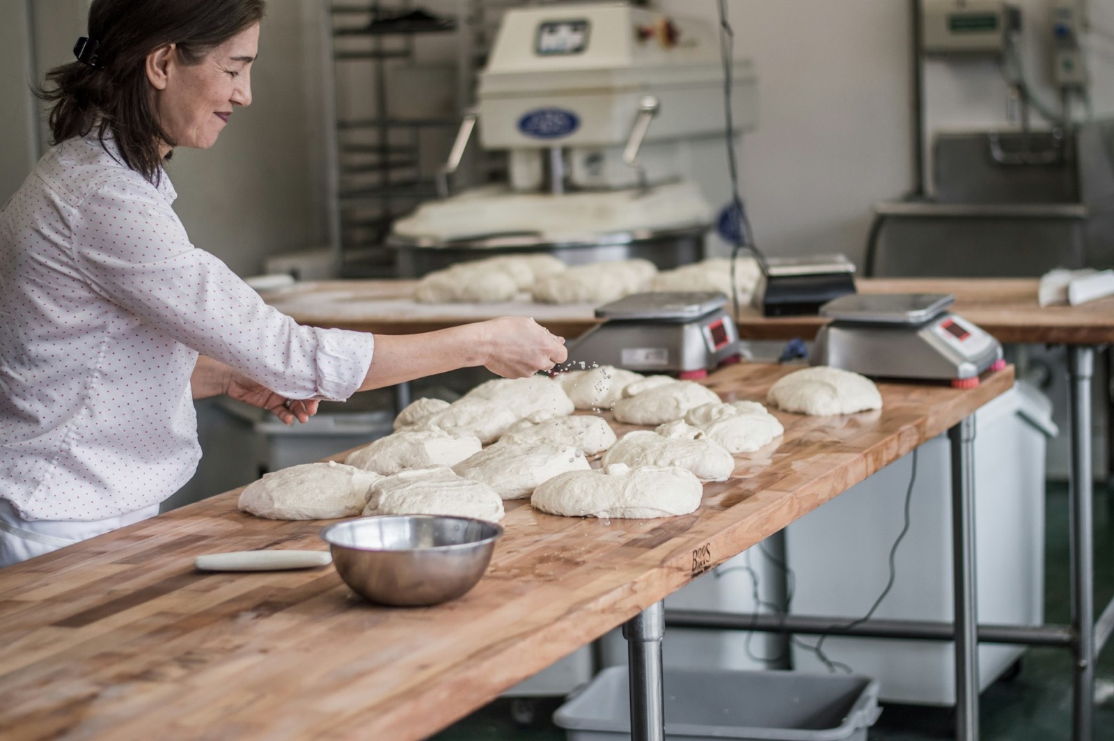 Leila dividing dough at the steel bench