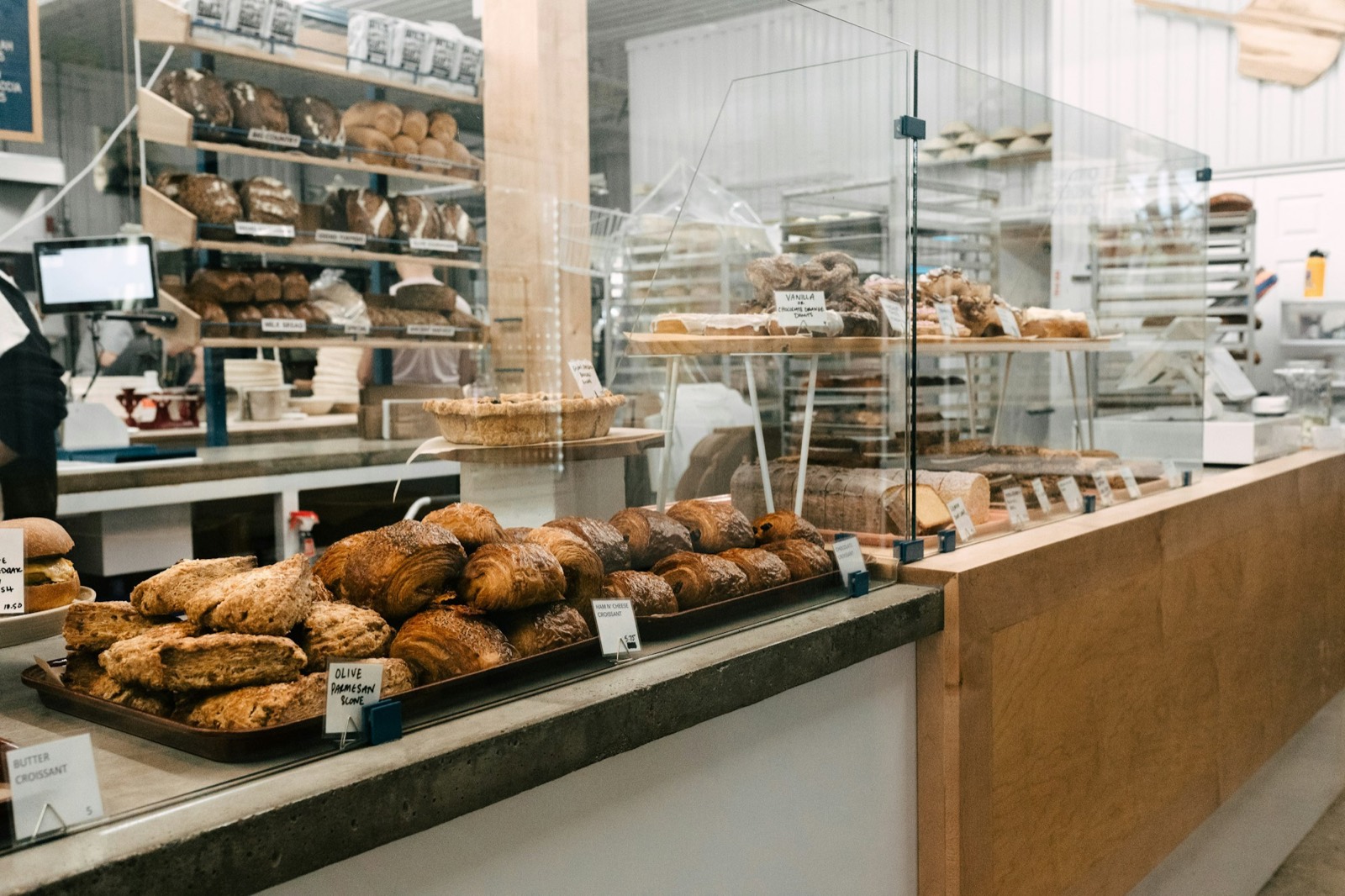The counter at opening: croissants and scones in front, loaves on the shelves behind