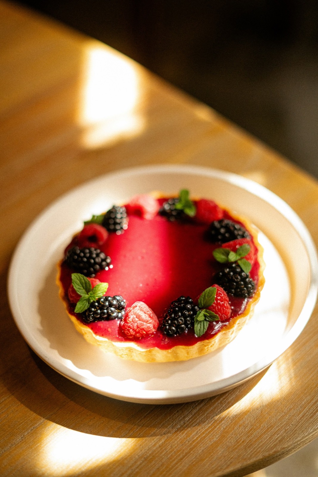 A berry tart in window light