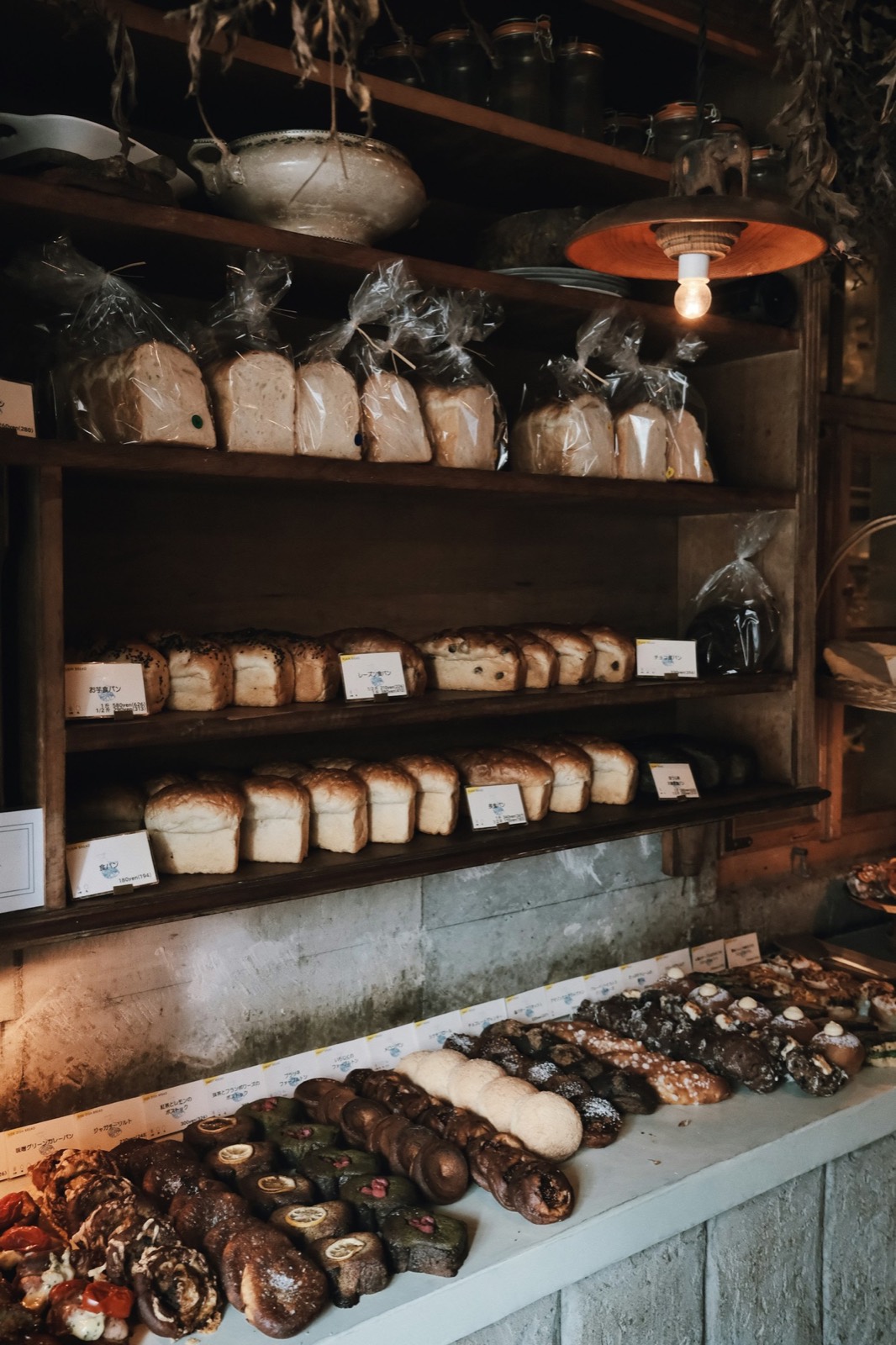Wooden shelves of loaves behind the counter