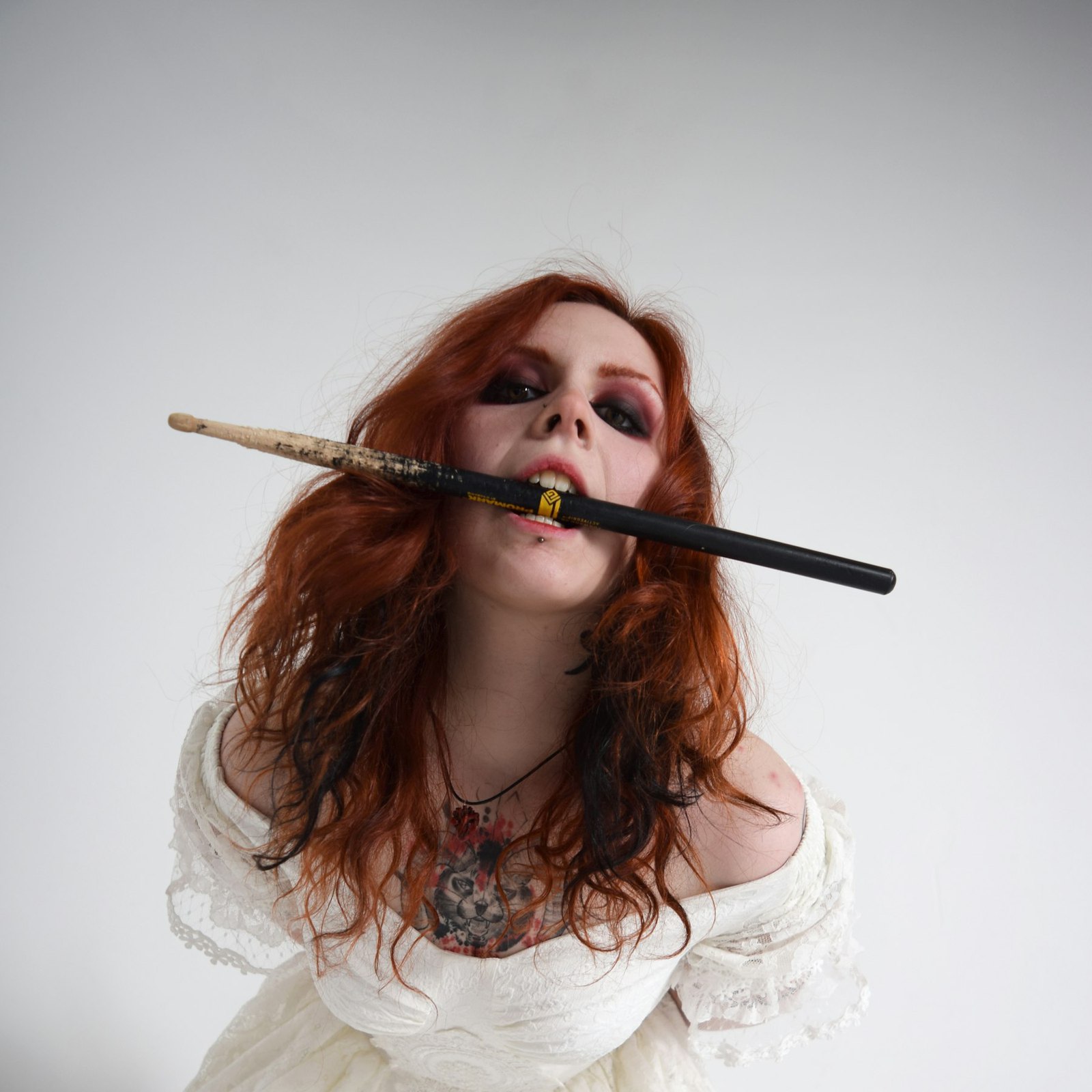 The cover of Bobbin: Ivy in a white dress holding a drumstick in her teeth.